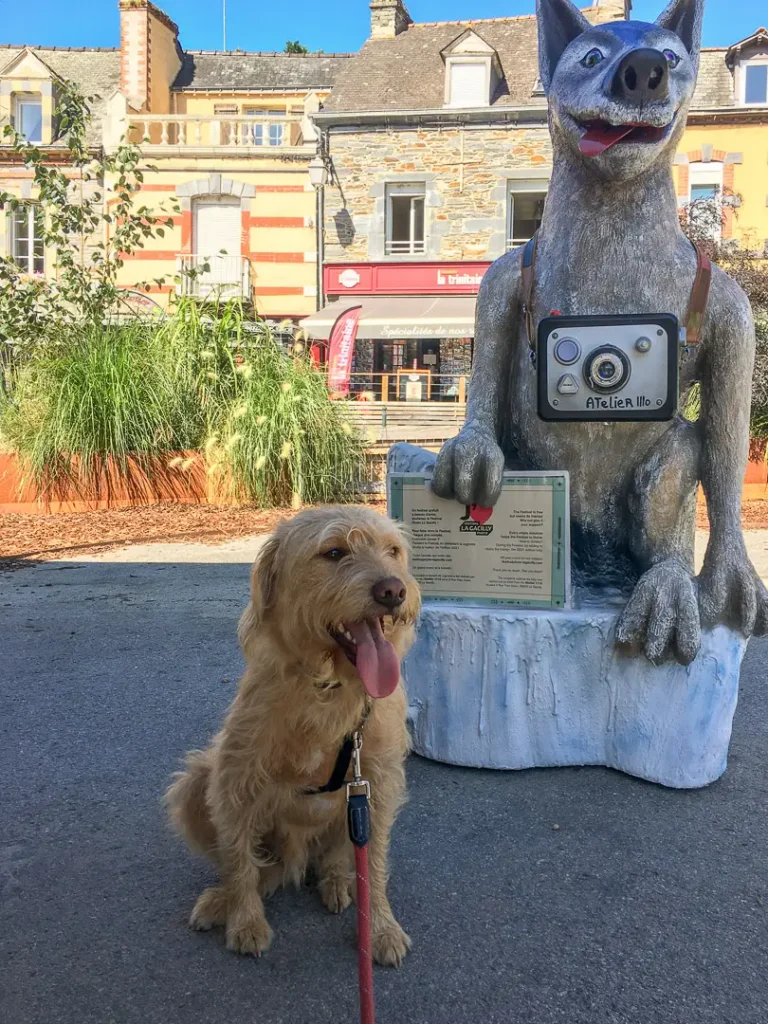 chien posant au pied d'une statue en forme de chien